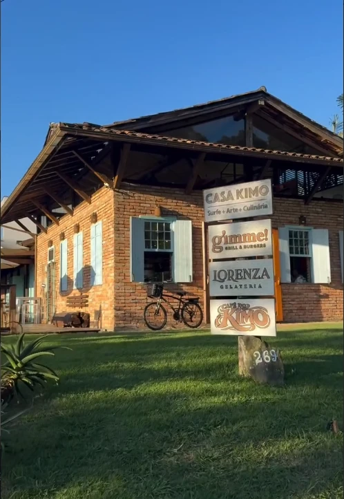 Fachada de tijolos da Casa Kimo, com placas do Café do Kimo, Lorenza Gelateria e gimme!